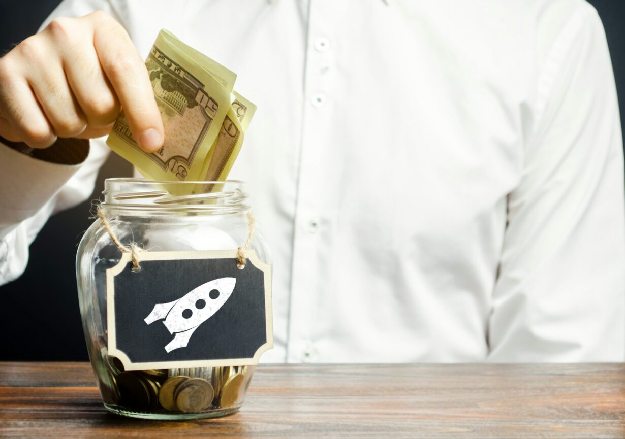 A man puts money into a startup jar. Research and development.