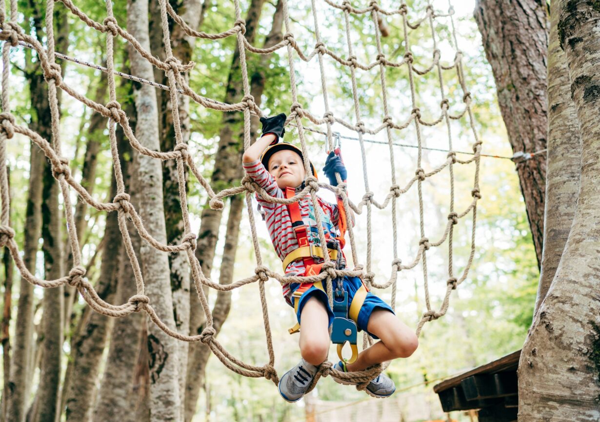 Boy climbing on a gladiator mesh in an adventure park