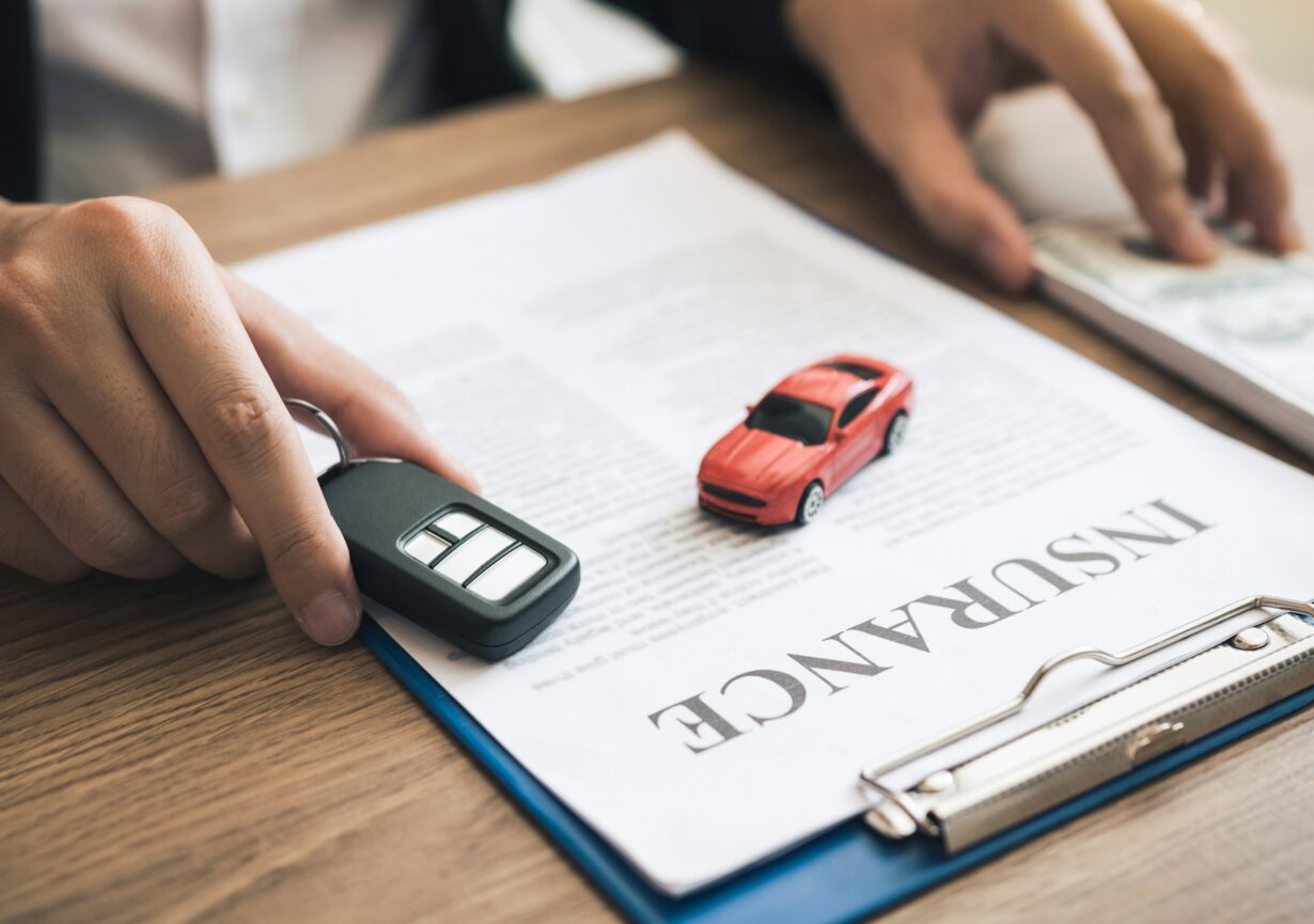 Car salespeople are holding car keys by submitting to new car buyers with car insurance concept.