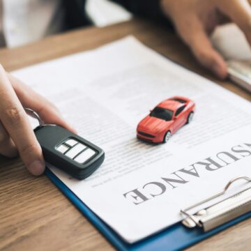 Car salespeople are holding car keys by submitting to new car buyers with car insurance concept.