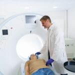 Doctor and female patient in the room of computed tomography at hospital. Healthcare concept