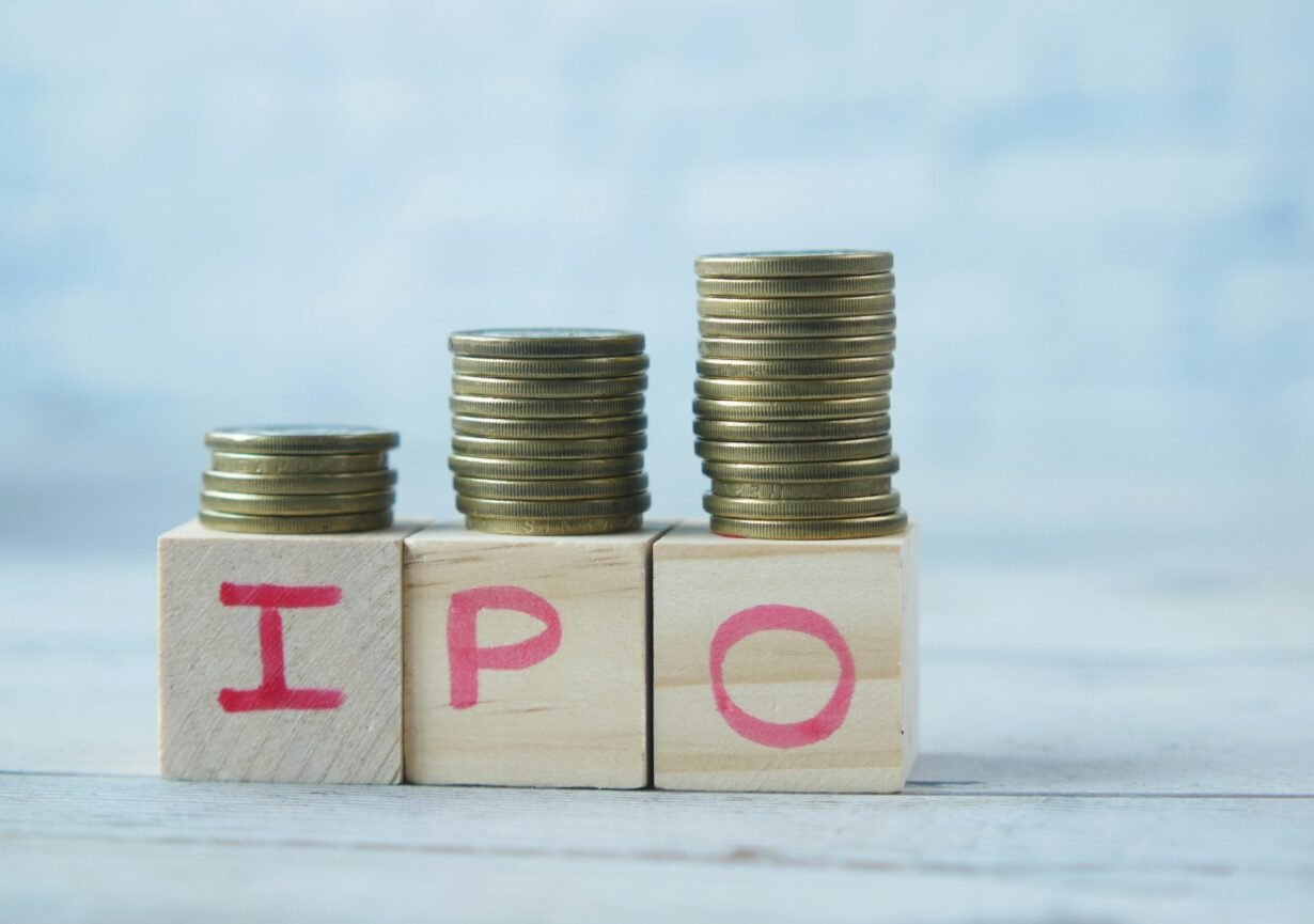 IPO text ,Initial Public Offering on wooden block with stack of coins