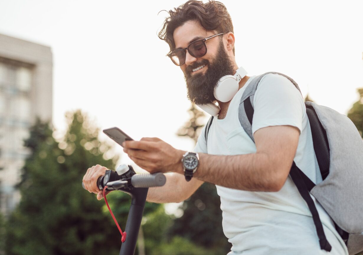 Smiling hipster using modern gadgets in everyday life