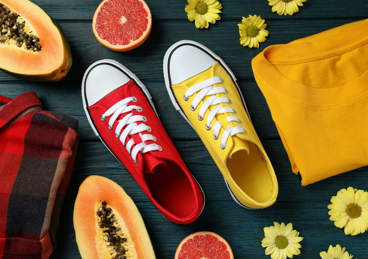 Summer clothes concept with sneakers on wooden background